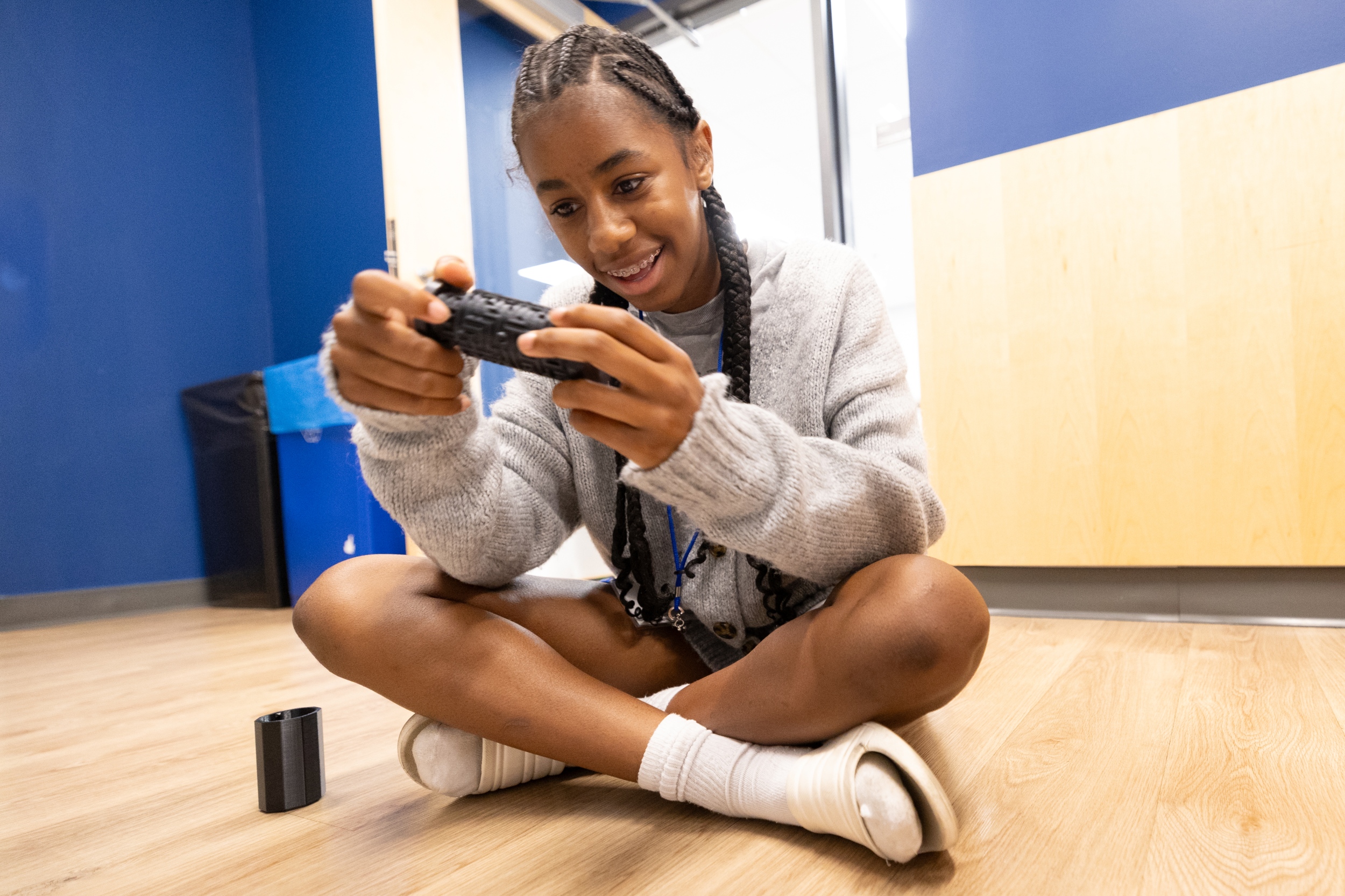 Girl holding some tech and smiling